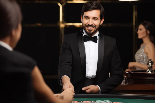 A woman in a luxurious green gown next to an ornate roulette wheel, capturing the upscale casino mood of RK888.